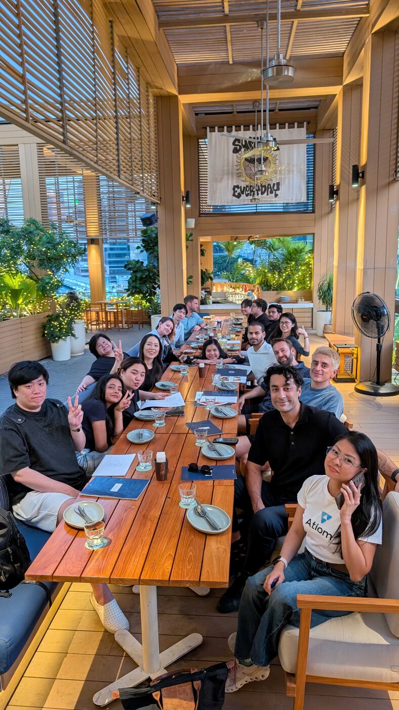 The Atiom team together at a long lunch table
